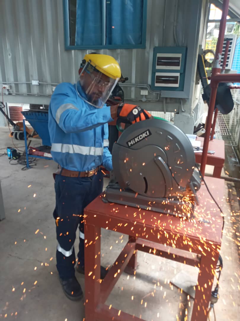 Student using a metal cut-off saw in the workshop