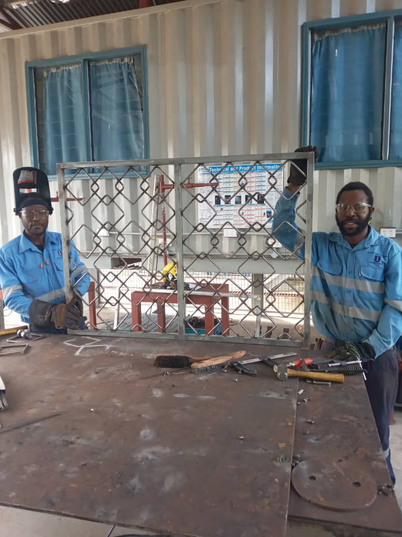 Metal Fabrication & Welding students with a finished steel window grille